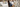 Woman leans over to touch a bed in a lineup at a store