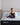 Tempur-Pedic memory foam lifestyle image with woman sitting on a Tempur mattress that has the head lifted by an adjustable base in a brightly lit room with plants